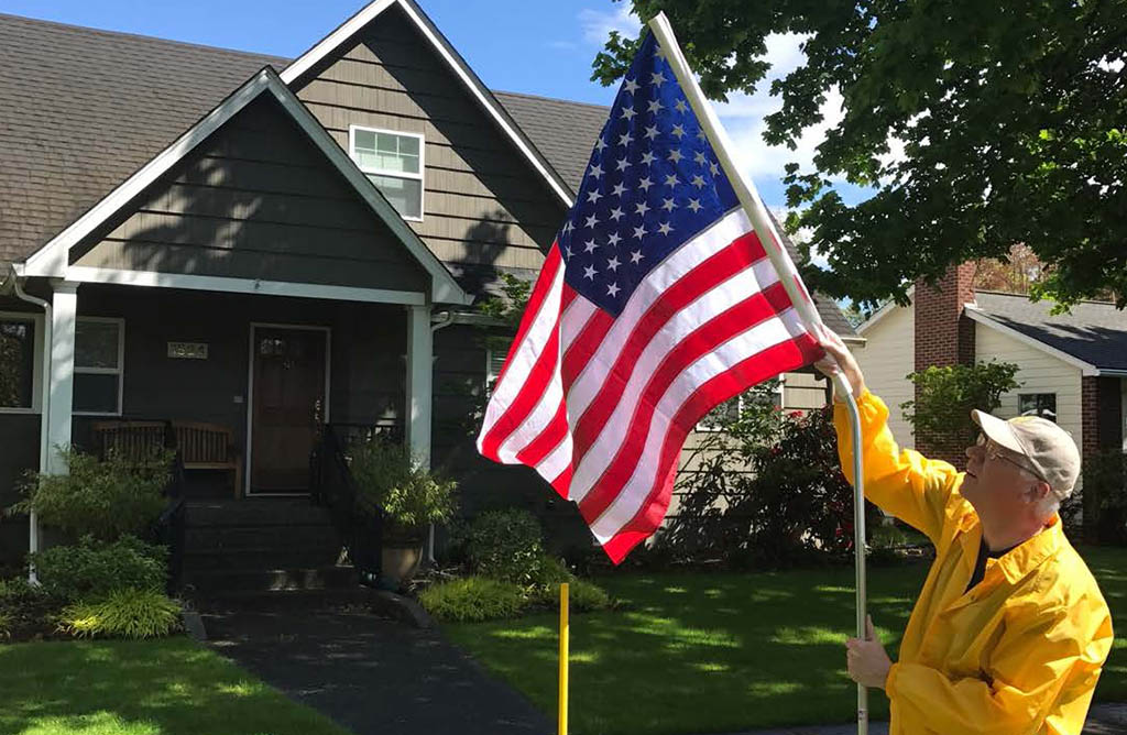 freedom flag deployment, man putting American flag on a pole 